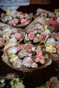 flower bouquets wrapped in craft paper. Top view of floral arrangements with pink roses, chrysanthemums and carnations for celebration
