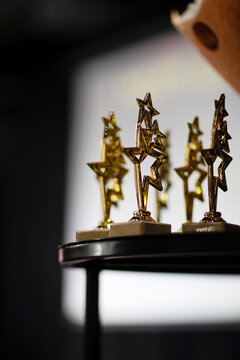 Golden star trophy awards on a dark blurred background. Concept of success, victory and recognition.