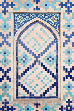Decorative tilework with pointed arch niche on Ulugh Beg Observatory in Samarkand, Uzbekistan. Geometric mosaic and floral arabesque patterns in blue and turquoise tiles ideal for travel and design.