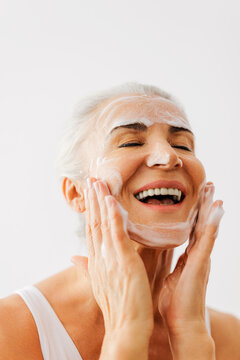 Mature woman enjoying daily face cleansing skincare routine