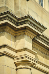Close Up of Traditional Sandstone Architectural Stonework Featuring Decorative Cornice Mouldings and Classical Column Detail © dannyburn