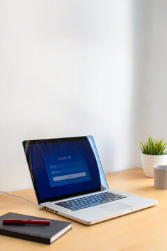 Laptop displaying login interface on wooden desk