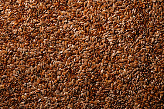 Brown flax seeds texture organic background. Top view of dry flaxseeds backdrop. Linseed for healthy snack food concept, oil production, vegetarian nutrition and agricultural design