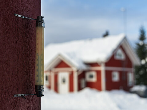 Close-up of winter thermometer on a house wall measuring freezing cold weather