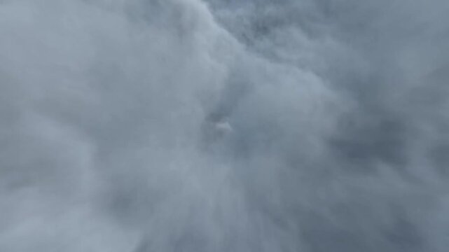 Dense gray storm clouds billow and swirl together across a dark overcast sky