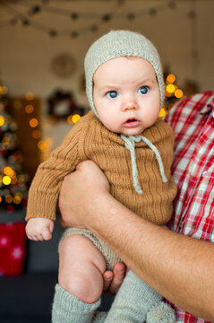 Happy family with a baby celebrating Christmas at home, enjoying cozy holiday moments together near a decorated Christmas tree in a warm festive atmosphere