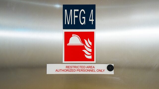 Restricted area authorized personnel only warning sign on industrial brushed metal surface