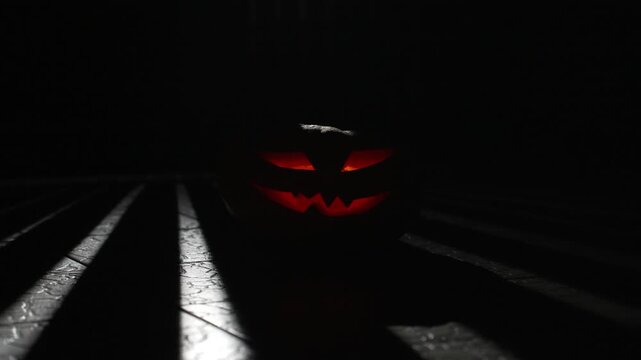 Dynamic light stripes and shadows moving across carved jack o lantern at night, cinematic 4k 120fps super slow motion footage