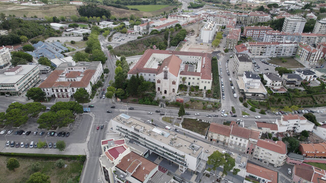 Aerial view of Igreja e Convento de Sao Francisco surrounded by urban streets, residential buildings, and green spaces in Leiria, Leiria, Portugal.