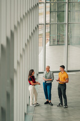 Business people collaborating and discussing ideas in modern office building with large windows