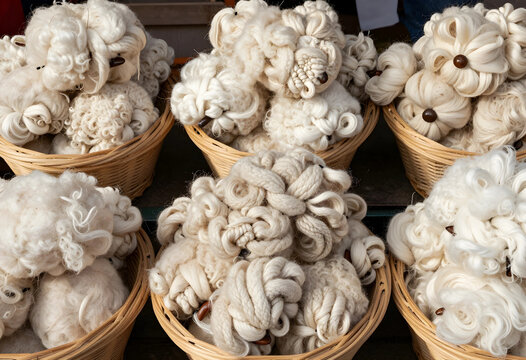 Sustainable textile production, raw sheep wool in woven baskets for traditional spinning and knitting craft, natural organic fiber for artisan goods