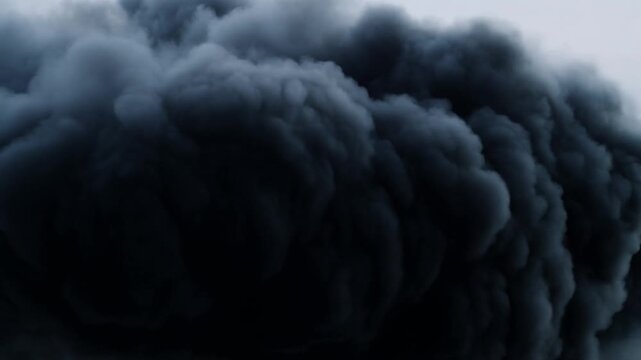 Dark storm clouds billow and roll across an overcast sky in turbulent motion