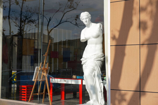 Statue behind glass, replica, street outdoor view. Longkou, China.