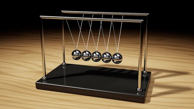 Newton's cradle with chrome balls swinging on a wooden desk, seamless loop