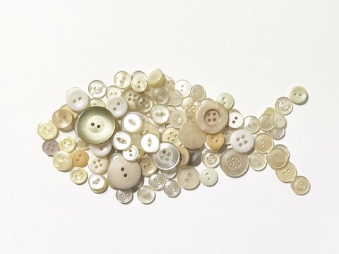fish-shaped object made from button collage, fish made with buttons, small fish button art, decorative illustration made with white buttons