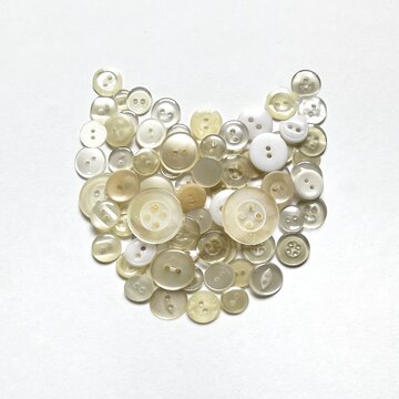 cat-shaped object made from button collage, cat face made with buttons, decorative illustration made with white buttons