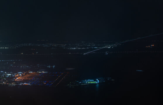 Aerial view of Santos Dumont Airport at night, with illuminated runways, taxiways, and city lights reflecting on the water in Rio de Janeiro, Rio de Janeiro, Brazil.