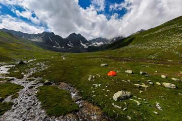 Orange Tent in Mountain Valley with Stream © yanik88