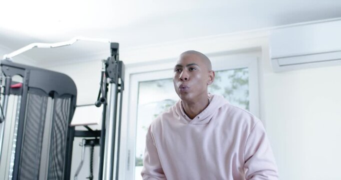African American man taking breath, reaching for 8 kg kettlebell and hinging, lifting for strength