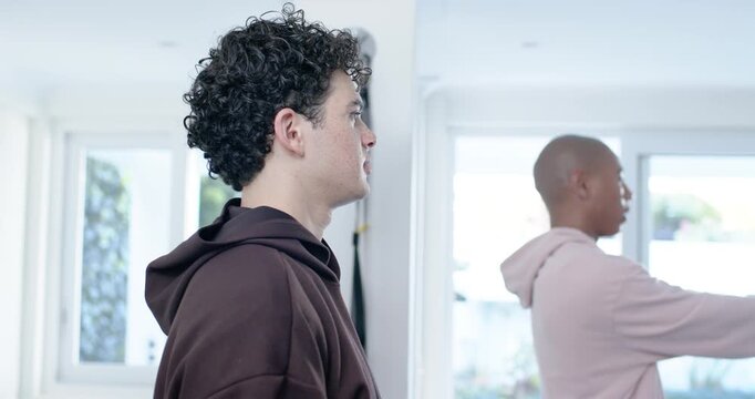 African American friends performing resistance-band rows in bright home, right man initiating pull