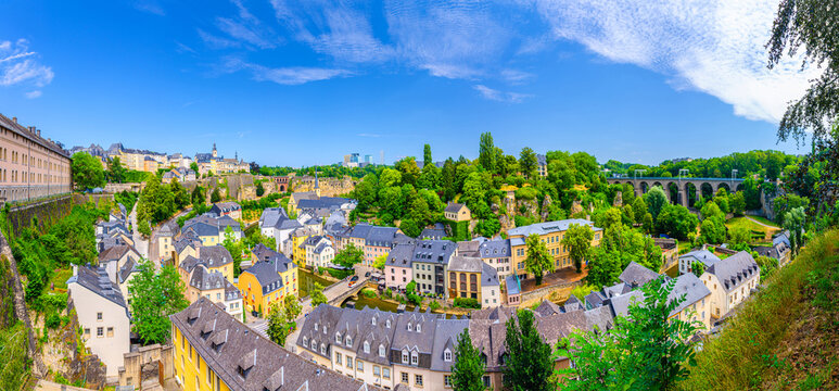 Luxembourg panorama, aerial panoramic view Luxembourg City centre, Luxembourg old town Grund and Ville Haute in Alzette river valley with Bock rocks, old buildings and green trees, Pulvermuhl viaduct