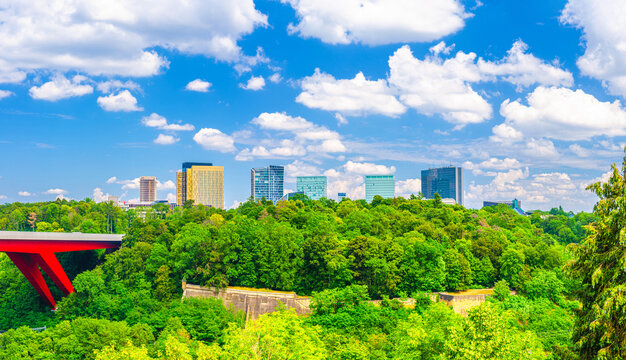 Luxembourg City aerial panoramic view of Kirchberg central business district with skyscraper buildings and Three Acorns Park with green trees, Panorama of Luxembourg cityscape skyline with blue sky