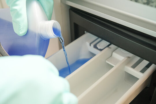 Washing machine cleaning, pouring liquid washing machine cleaner into the detergent drawer, household cleaning routine and appliance care