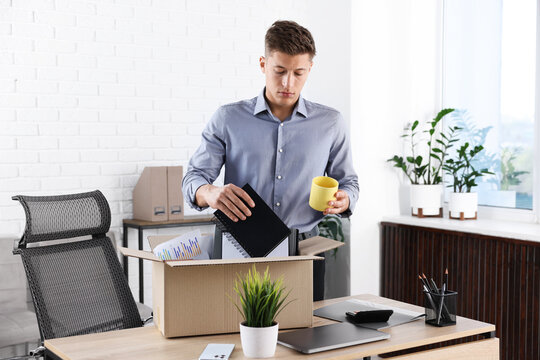 Man packing his things after being fired in office. Concept of unemployment