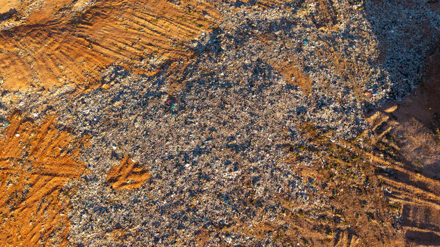 Aerial view of an informal pig farm at a landfill site with animals feeding from discarded waste in Ladismith, Western Cape, South Africa.