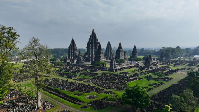 Aerial view of Prambanan Temple, an ancient Hindu temple complex with towering stone spires set amidst lush green grounds in Kecamatan Prambanan, Daerah Istimewa Yogya, Indonesia.