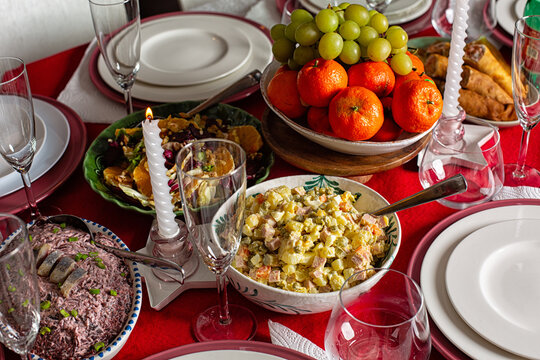 New Year&rsquo;s table,  Soviet-era traditions, feast filled with classic salads, Olivier or Russian Salad, Herring Under a Fur Coat, fresh fruit, tangerine and grape, crepes rolls. Life style dinner.