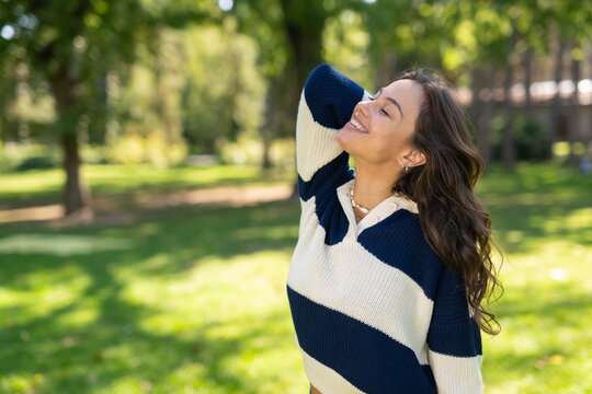 Woman enjoying freedom and sunlight in park