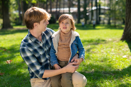 Father comforting child crying in a park