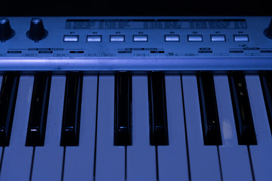Macro view of electronic keyboard keys and control panel on dark stage