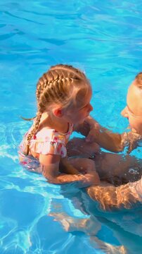 Children are swimming and playing in the pool. Selective focus.