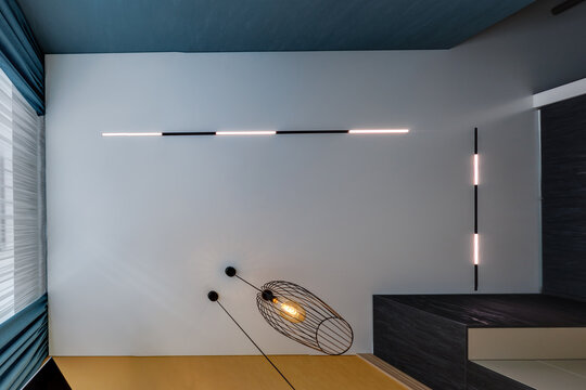 suspended ceiling with halogen spots lamps and drywall construction in empty room in apartment or house. Stretch ceiling white and complex shape.