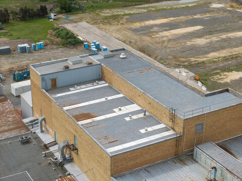 Melbourne, Australia - 14 October 2026: Aerial view of the Bayswater North Factories industrial complex, featuring brick buildings, metal roofing, and surrounding vacant land.