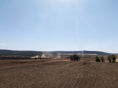 Aerial View of Tractor Plowing and Leveling a Large Agricultural Field in Italy