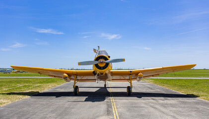 Yellow Agricultural Airplane with Wide Wingspan Parked on Airfield Taxiway in Summer © Diatlova Tetiana