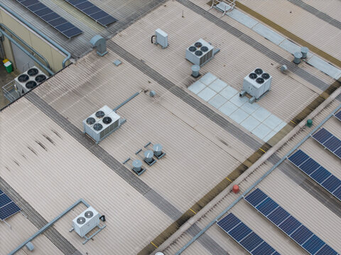 Melbourne, VIC, Australia - 14 October 2026: Aerial view of the industrial rooftops at Bayswater North Factories featuring multiple HVAC units and rows of solar panels.