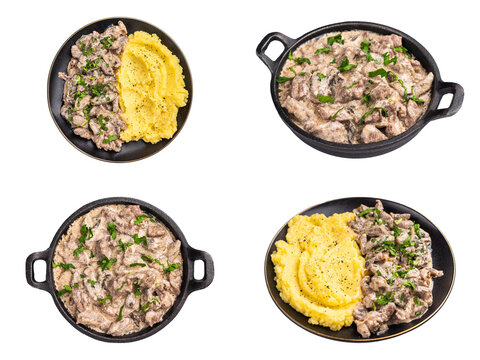Four beef stroganoff servings with creamy sauce chopped herbs and mashed potatoes arranged in dark dishes isolated on white