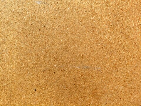 Close-up texture of brown hardboard or fiberboard building material surface