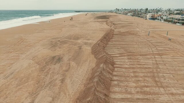 Long sand berms stretch along Newport Beach coastline to help defend the shore from high tides.