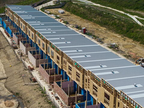 Melbourne, Australia - 08 October 2026: Aerial view of a row of townhouses under construction with wooden framing and metal roofing in a suburban development area.