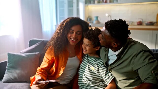 Mother taking selfie phone with son father home sofa. Smiling family weekend.