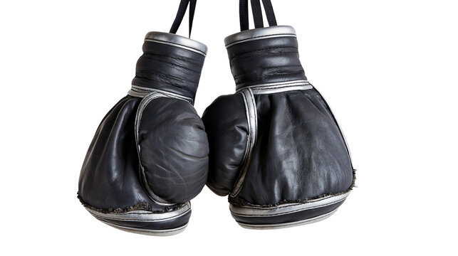 Isolated pair of black and silver boxing gloves hanging, symbolizing strength and sports training.