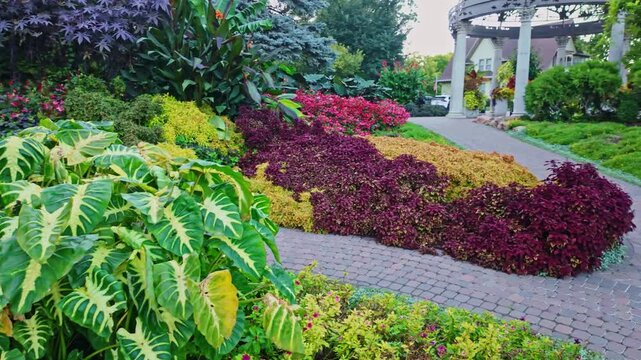 Vibrant botanical garden path leading past colorful coleus and ornate dome gazebo at Sunken Gardens in Lincoln Lancaster County Nebraska