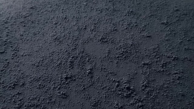 Gray granular surface texture fills the view with subtle tonal variation