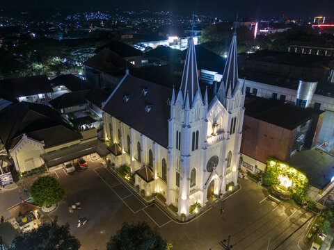 Kecamatan Klojen, Indonesia - 09 October 2026: Aerial view of the illuminated Church of the Sacred Heart of Jesus in the Kayutangan Heritage area, with twin spires at night.