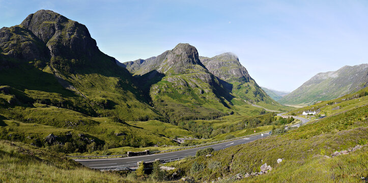 Summer view of the Three Sisters of Glencoe in the highlands of Scotland, showing Beinn Fhada, Coire Gabhail, Gearr Aonach, and Aonach Dubh. The, now notorious, Allt na Reigh cottage can also be seen.
